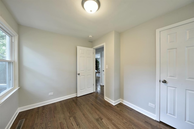 unfurnished bedroom with dark wood-type flooring