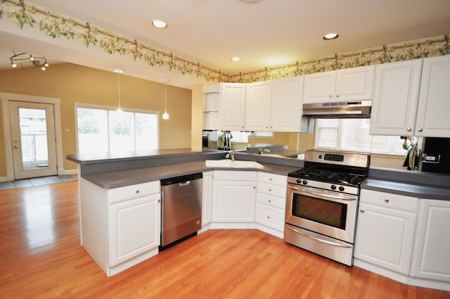 kitchen featuring appliances with stainless steel finishes, white cabinetry, kitchen peninsula, and light wood-type flooring