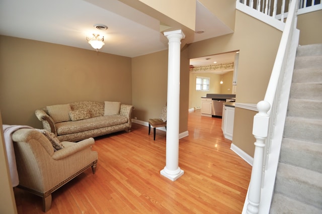 living room with ornate columns and light hardwood / wood-style flooring