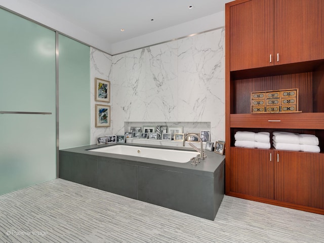 bathroom featuring a bath and tile floors