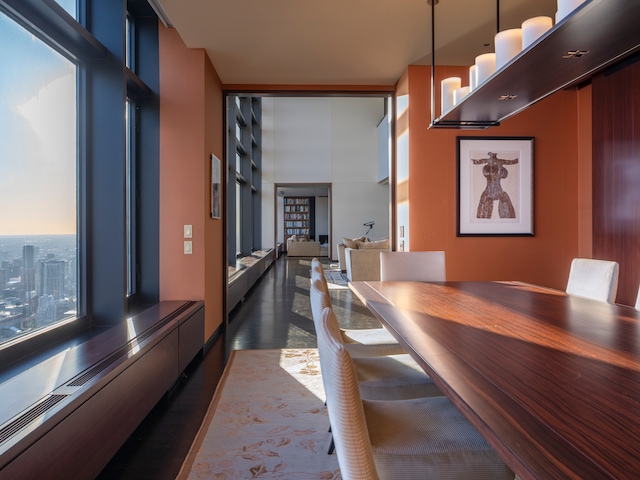 unfurnished dining area featuring baseboard heating, floor to ceiling windows, and dark hardwood / wood-style floors