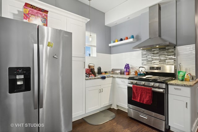 kitchen with appliances with stainless steel finishes, white cabinetry, dark hardwood / wood-style floors, backsplash, and wall chimney range hood