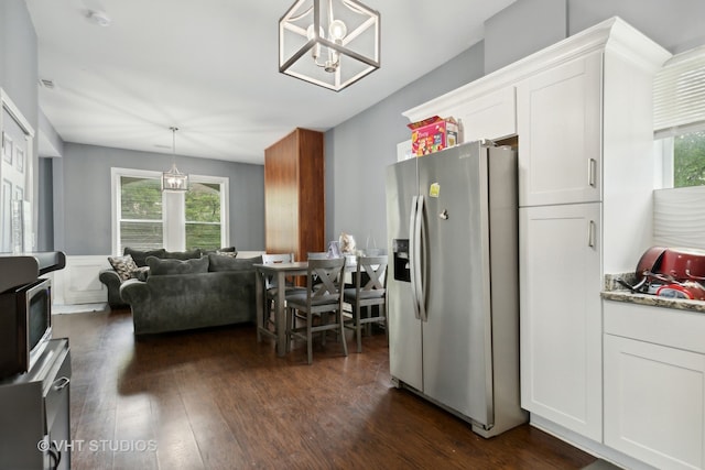 kitchen featuring dark wood-type flooring, light stone counters, white cabinetry, pendant lighting, and stainless steel refrigerator with ice dispenser