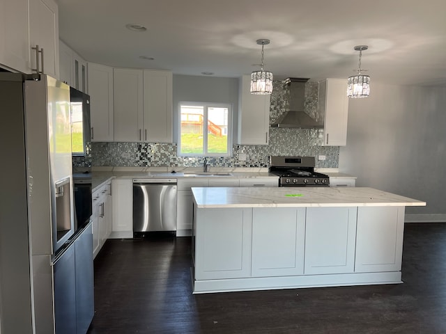 kitchen with dark wood-type flooring, appliances with stainless steel finishes, tasteful backsplash, white cabinets, and wall chimney exhaust hood