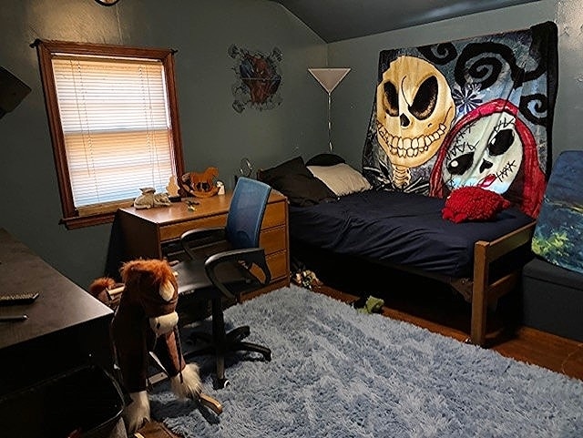 bedroom with dark wood-type flooring and lofted ceiling