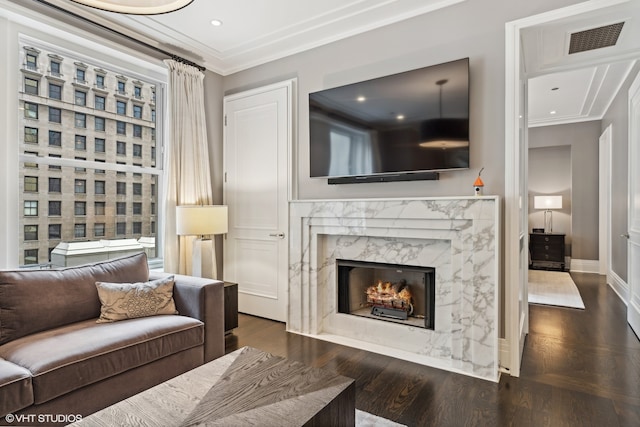 living room with a high end fireplace, crown molding, and dark hardwood / wood-style floors