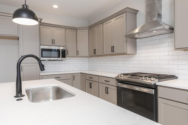 kitchen with appliances with stainless steel finishes, tasteful backsplash, wall chimney exhaust hood, and sink