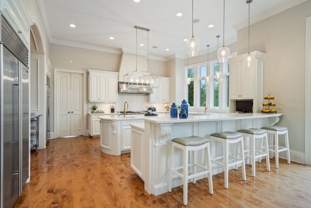 kitchen featuring backsplash, white cabinets, decorative light fixtures, kitchen peninsula, and a breakfast bar area