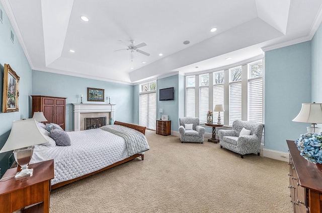 bedroom featuring ceiling fan, carpet floors, ornamental molding, and a tray ceiling