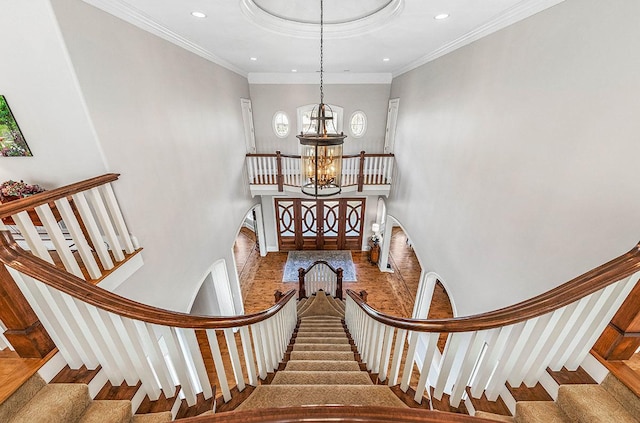 staircase featuring a notable chandelier and ornamental molding