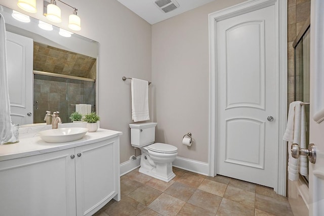 bathroom featuring vanity, toilet, and a shower with shower door