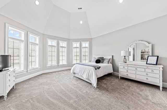 carpeted bedroom with multiple windows and lofted ceiling