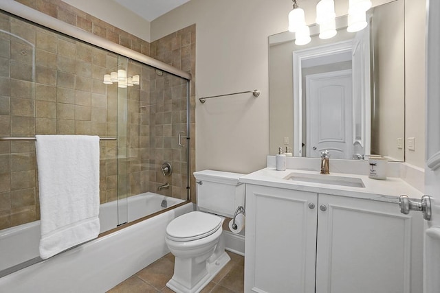 full bathroom featuring shower / bath combination with glass door, vanity, tile patterned floors, and toilet