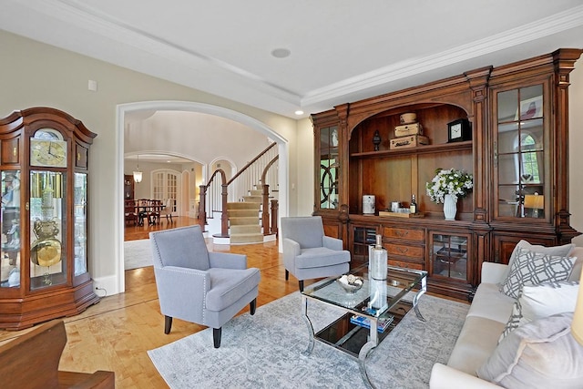 living room featuring light hardwood / wood-style floors, a raised ceiling, and ornamental molding