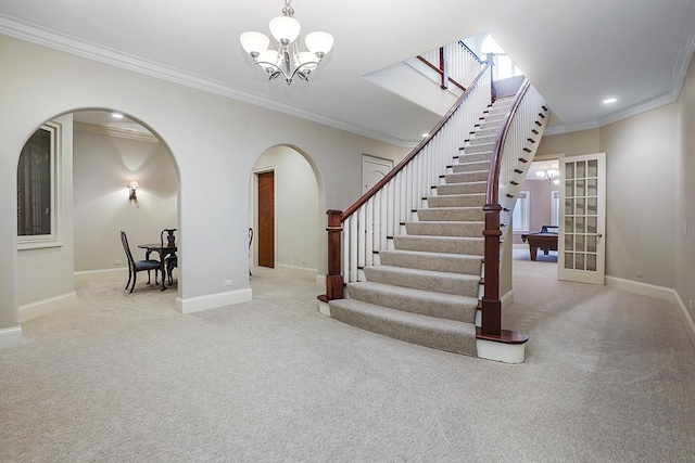 stairs featuring carpet flooring, french doors, a chandelier, and ornamental molding