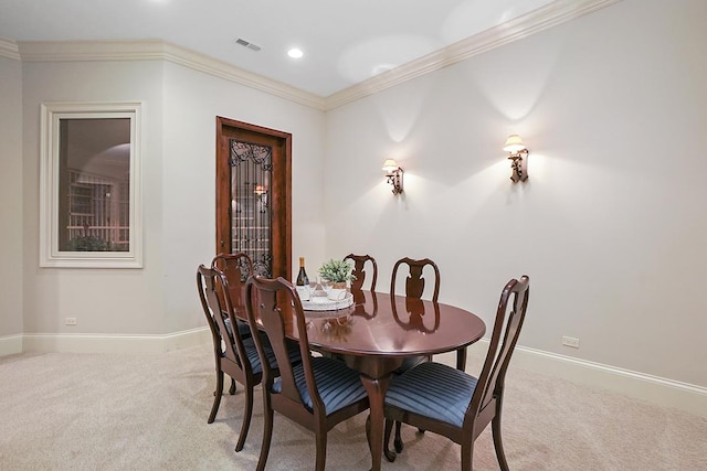 dining room with light carpet and crown molding