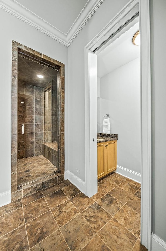 bathroom with vanity, an enclosed shower, and crown molding