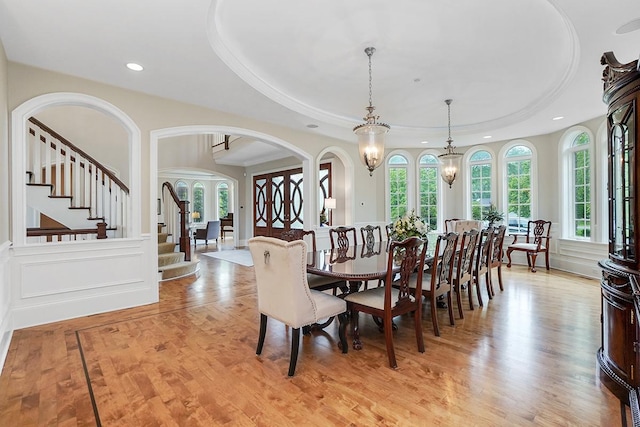 dining room with french doors, a raised ceiling, and a wealth of natural light