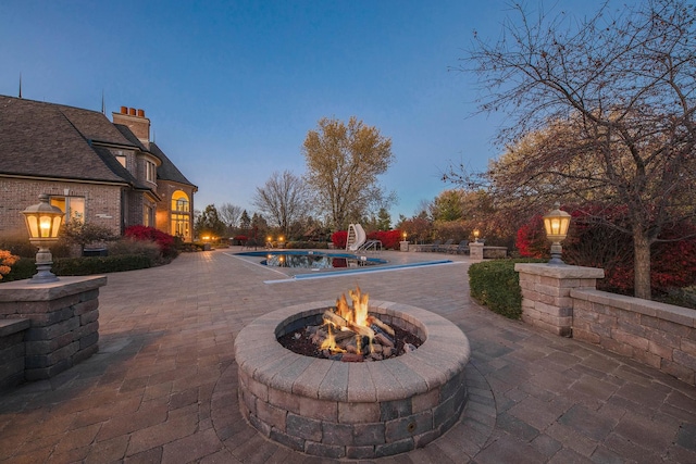 patio terrace at dusk featuring a fire pit