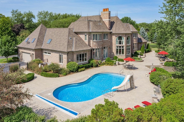 view of swimming pool with a patio area and a water slide