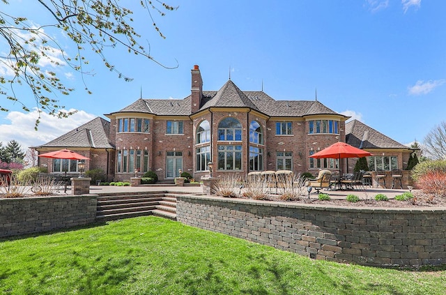 rear view of house featuring a yard and a patio