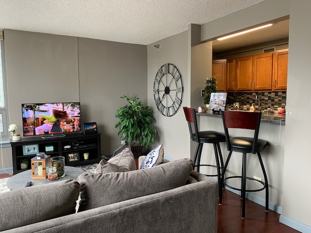 living room with a textured ceiling and dark hardwood / wood-style floors