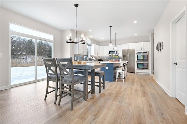 dining space featuring a chandelier and light hardwood / wood-style floors