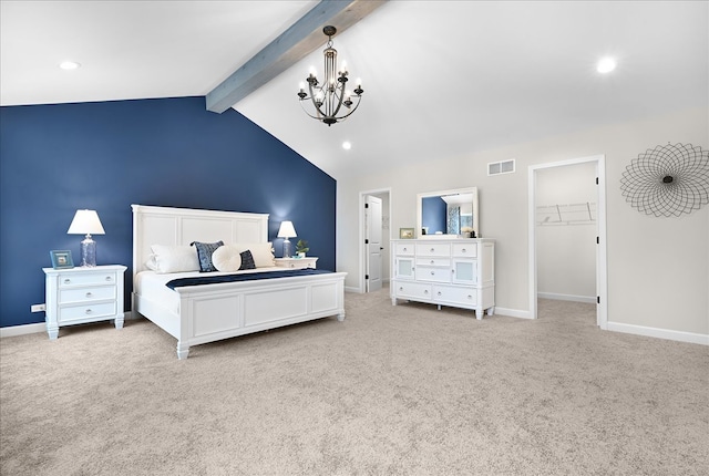 bedroom with a notable chandelier, a walk in closet, and light colored carpet