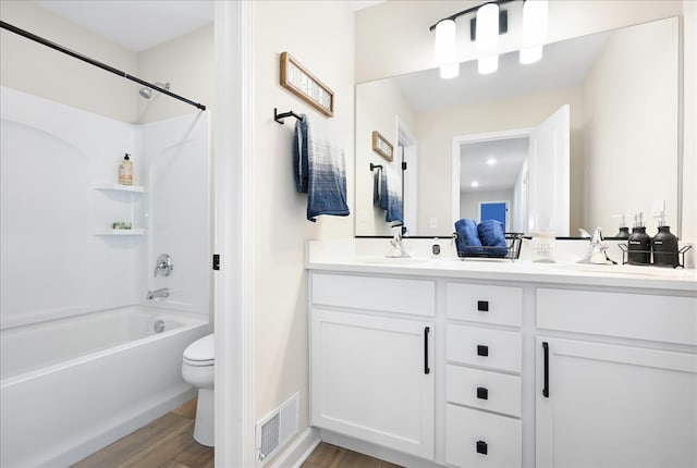 full bathroom featuring toilet, washtub / shower combination, dual vanity, and wood-type flooring