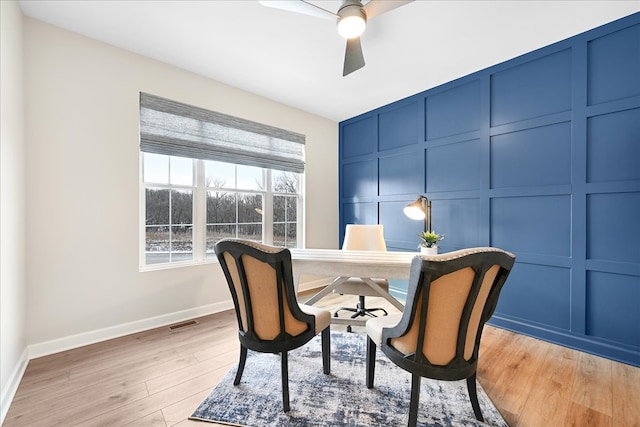 home office with light hardwood / wood-style floors and ceiling fan