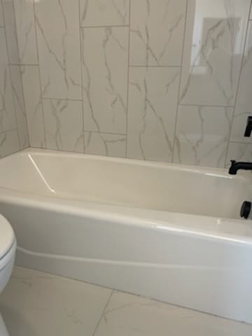 bathroom featuring tile flooring and toilet