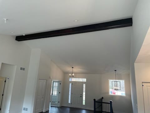 interior details with dark hardwood / wood-style flooring, an inviting chandelier, and beam ceiling