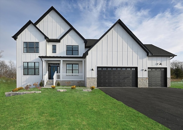 modern farmhouse featuring a front lawn, a porch, and a garage