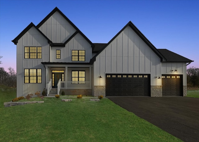 modern farmhouse featuring a yard, a porch, and a garage