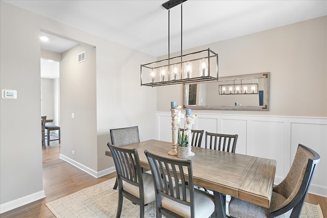 dining room with a notable chandelier and wood-type flooring