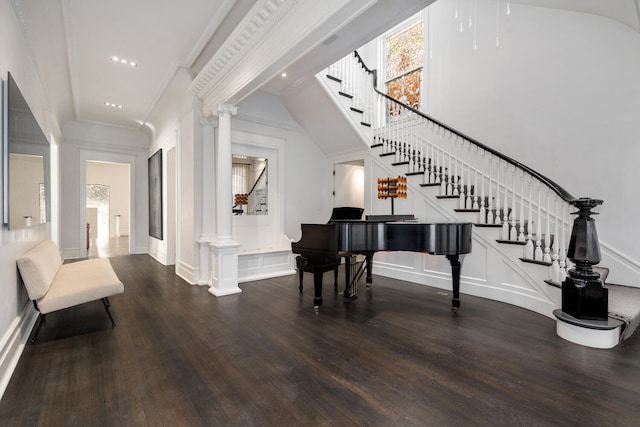 entryway featuring decorative columns, ornamental molding, and dark hardwood / wood-style floors