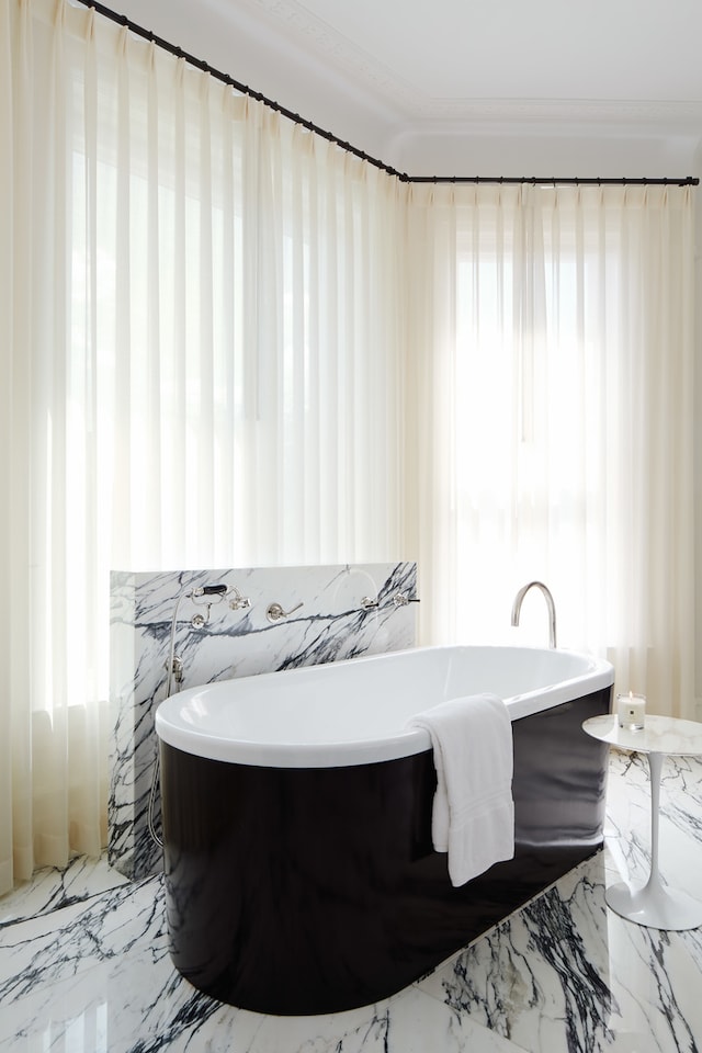 bathroom featuring a tub, tile flooring, and a wealth of natural light