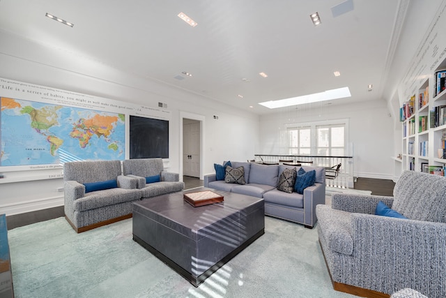 living room with crown molding, light wood-type flooring, and a skylight