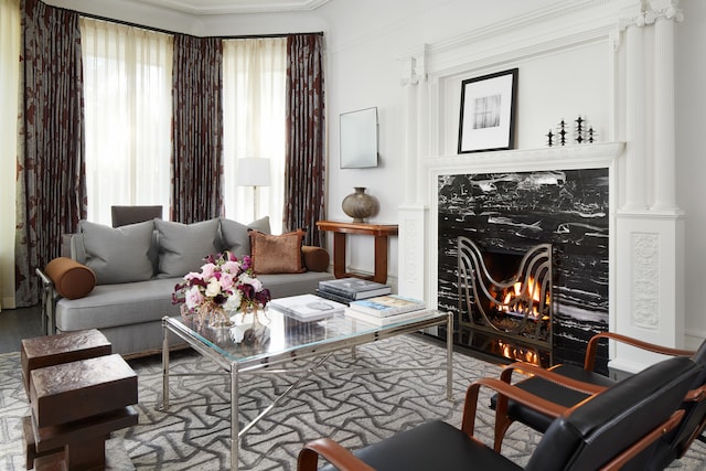 sitting room featuring a high end fireplace, ornamental molding, and hardwood / wood-style flooring