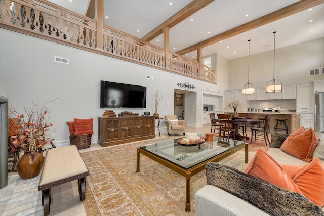 living room with a towering ceiling and beam ceiling