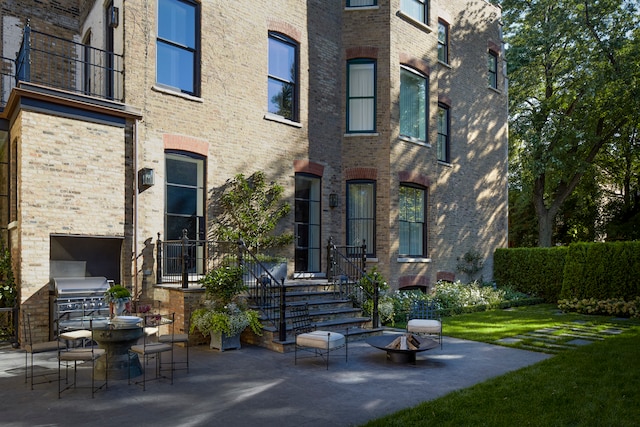 exterior space with a balcony, exterior kitchen, and a patio