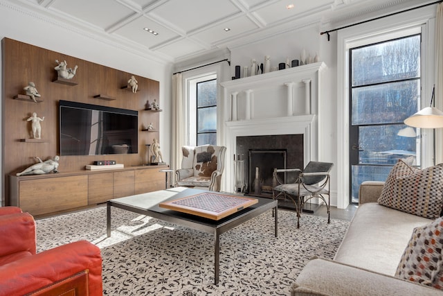 living room featuring coffered ceiling, ornamental molding, and a wealth of natural light