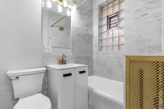 full bathroom with tile walls, toilet, vanity, and tiled shower / bath