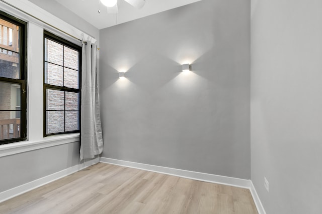 empty room with ceiling fan and light hardwood / wood-style flooring