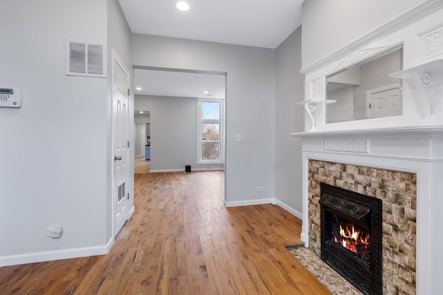 unfurnished living room featuring light hardwood / wood-style flooring and a fireplace