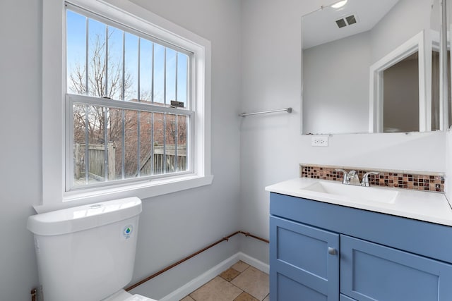 bathroom featuring vanity, tile floors, a wealth of natural light, and toilet