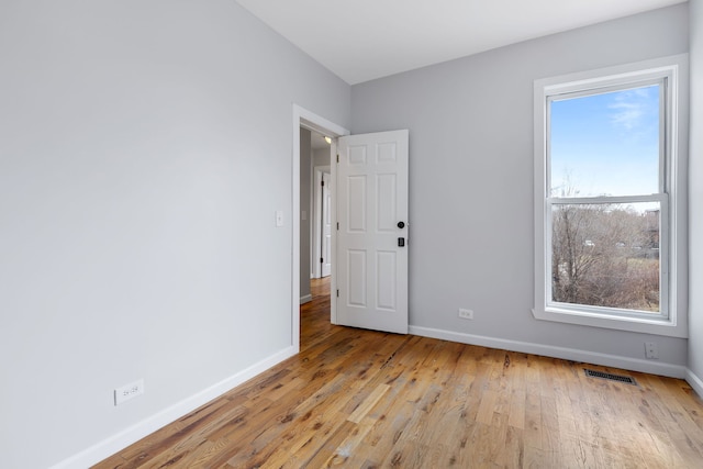 spare room featuring plenty of natural light and light hardwood / wood-style flooring