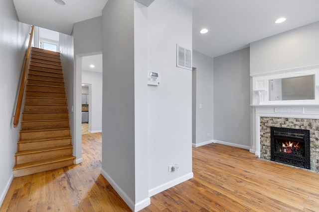 unfurnished living room with a fireplace and light hardwood / wood-style floors