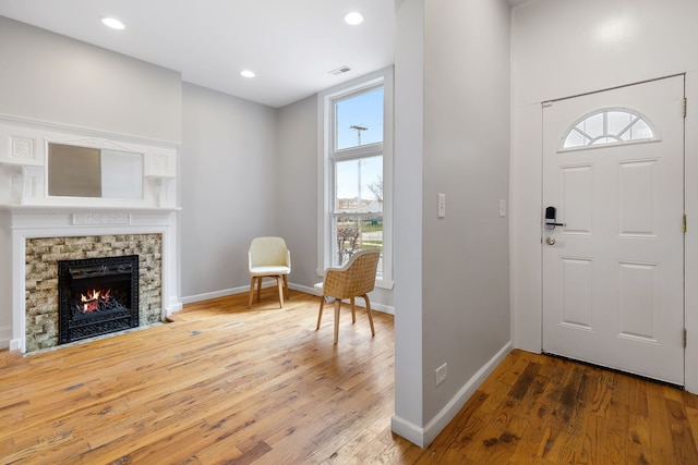 entryway with light hardwood / wood-style flooring, a fireplace, and plenty of natural light