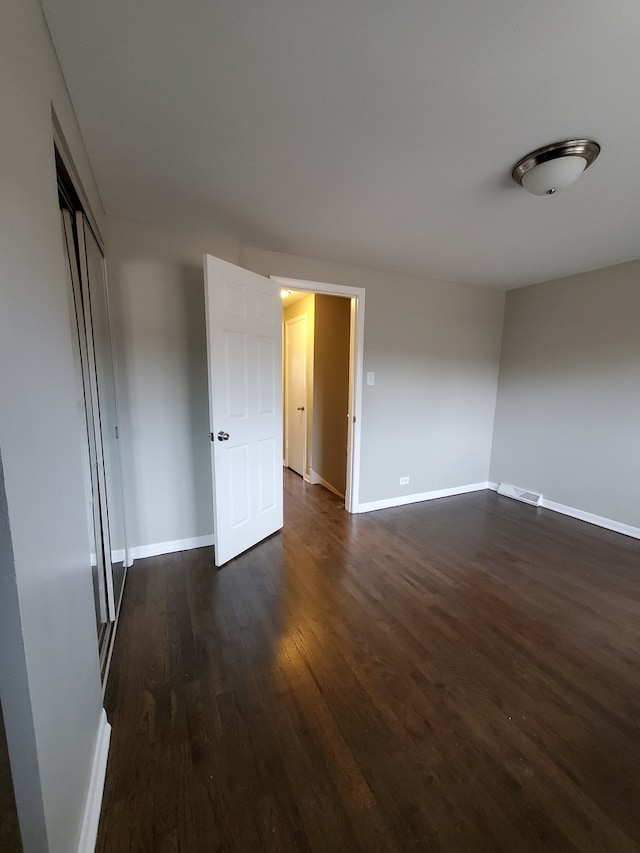 unfurnished room with dark hardwood / wood-style floors